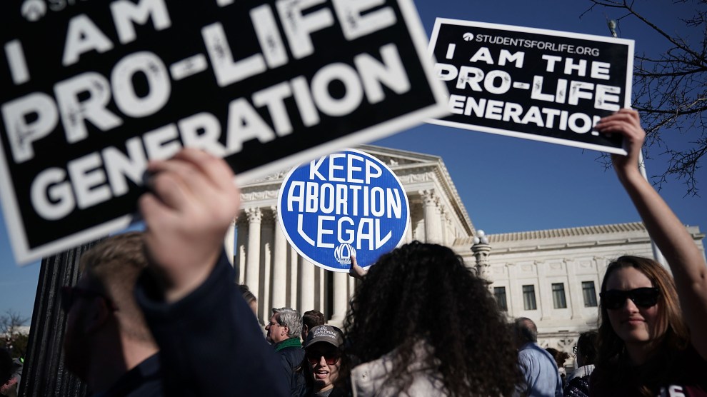 Pro-life activists try to block the sign of a pro-choice activist during the 2018 March for Life January 19, 2018 in Washington, DC.