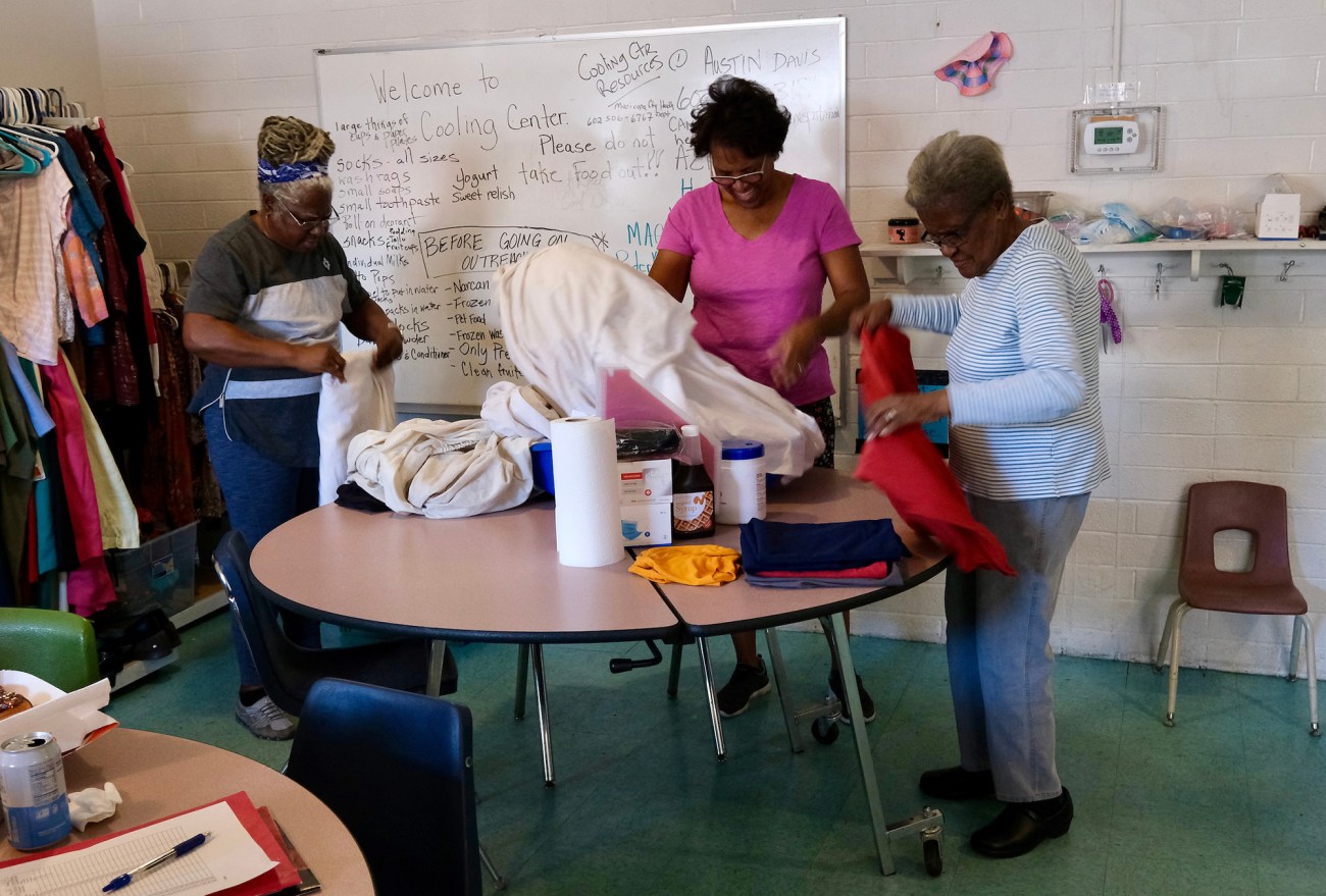 Group of people standing around a table.