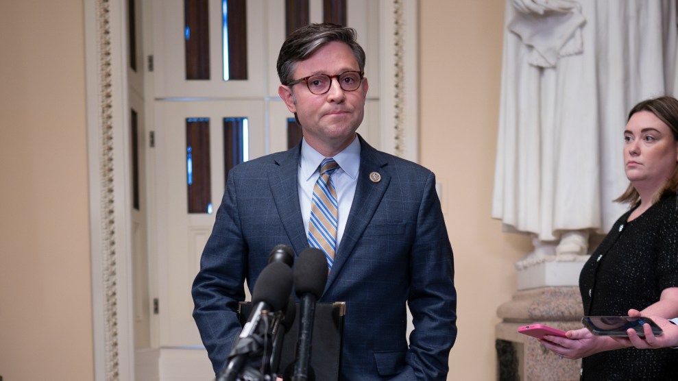 Speaker Mike Johnson stands in front of a microphone.