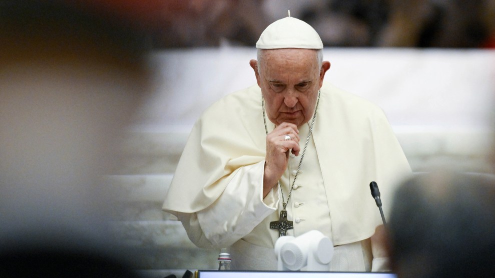 Pope Francis looks down with his hand brought to his chin.