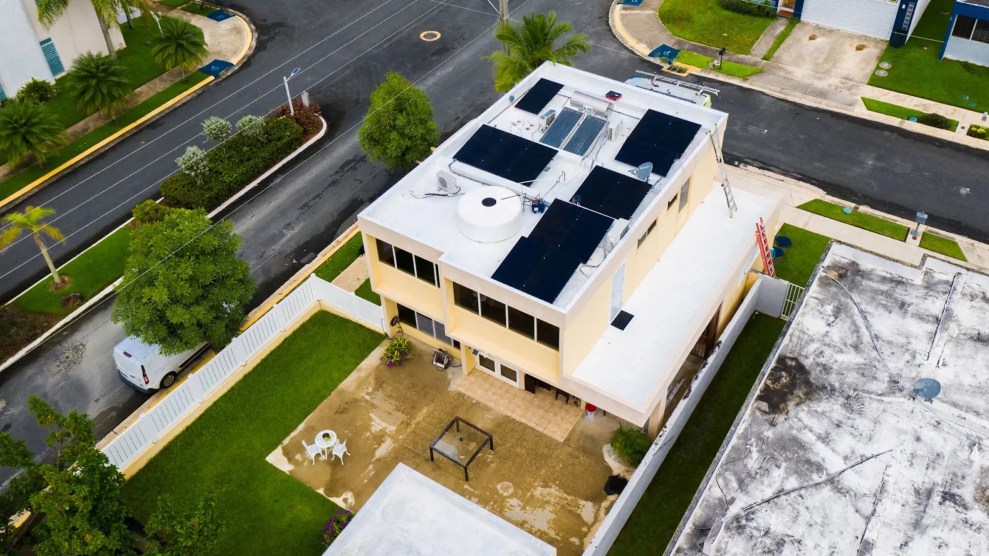 Soiar panels on top of a two-story yellow house