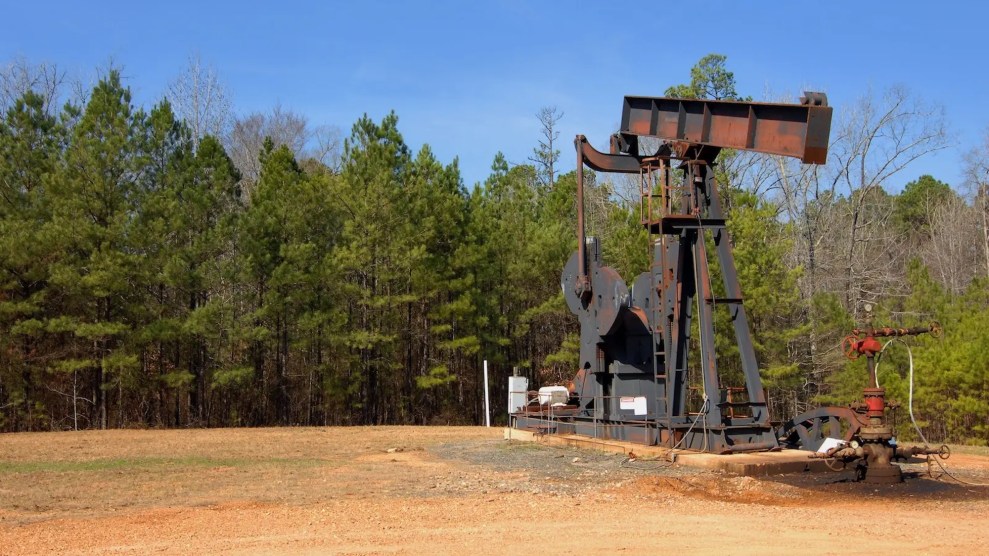 Oil rig on faded grass with trees behind them