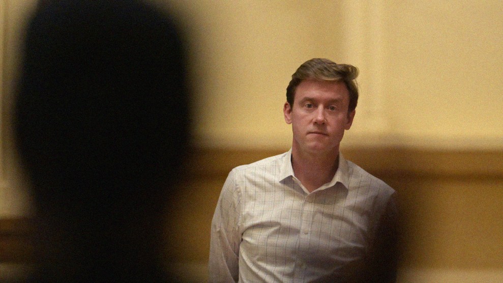 Denver mayor Mike Johnston looks at someone in silhouette in the foreground of the picture asking a question during a town hall meeting at the Central Presbyterian Church in Denver.