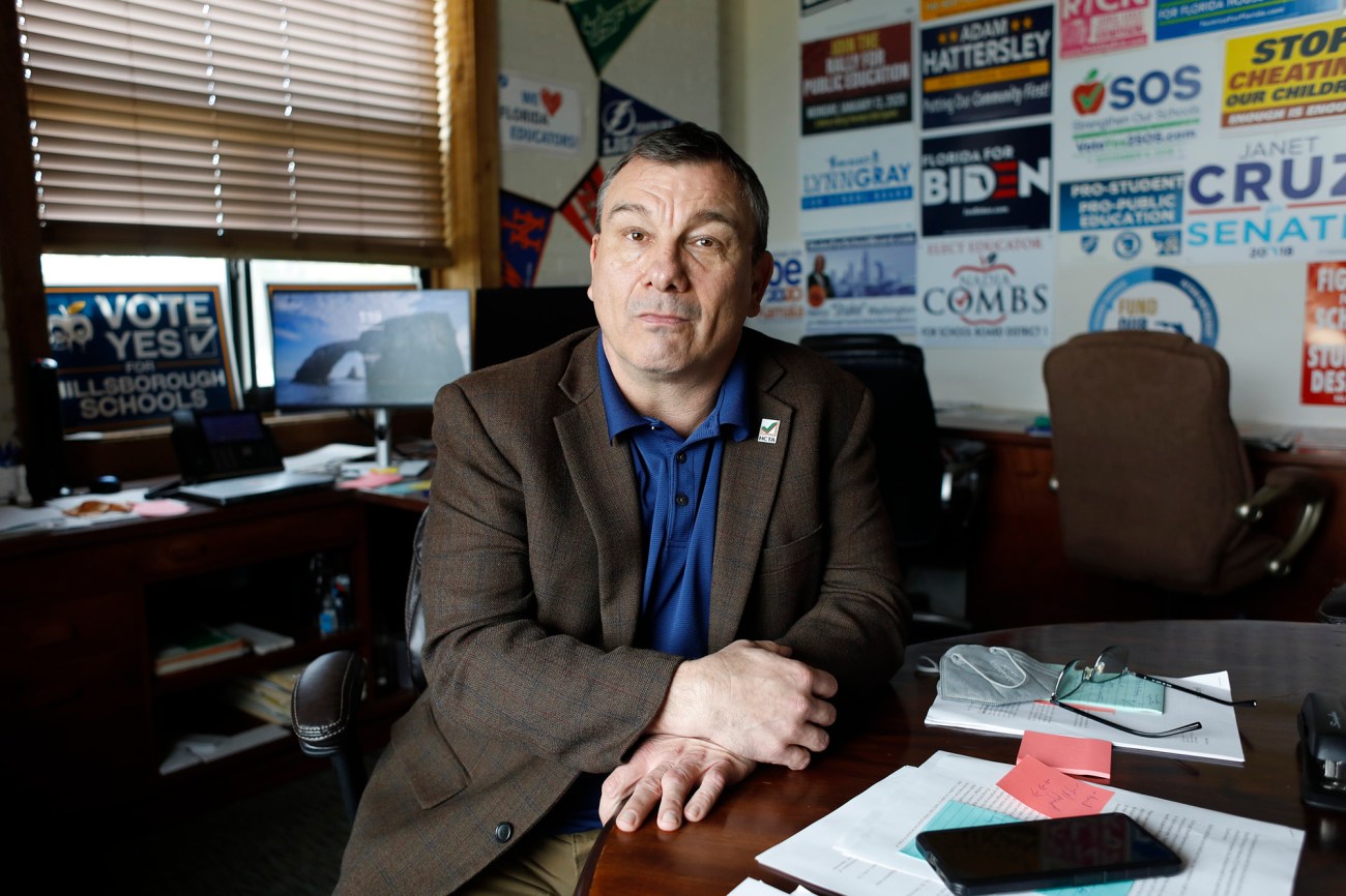 Man sitting at a desk with signs on the walls.