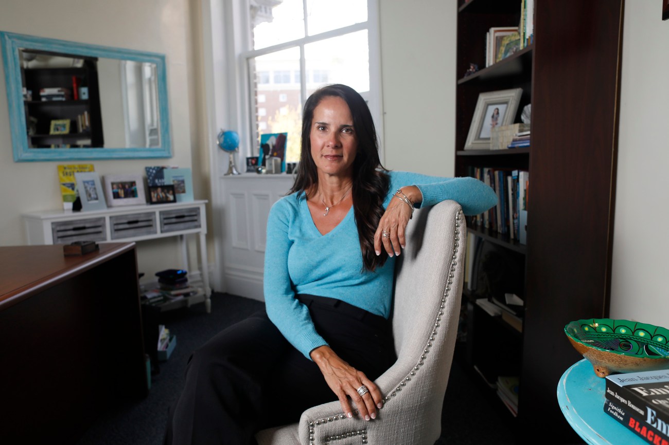 Portrait of woman in a blue sweater sitting in a chair.