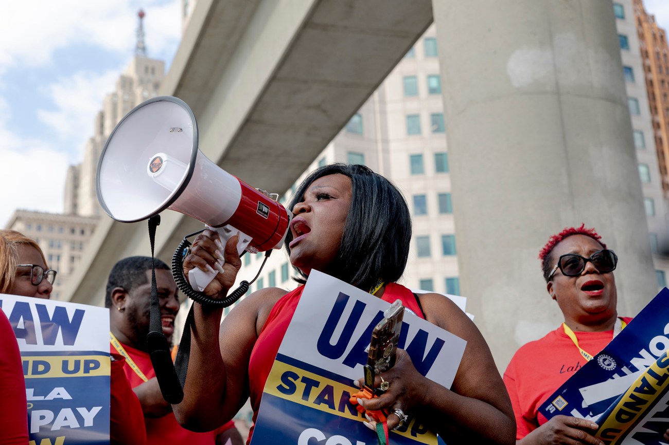 Woman with bullhorn speaking to a crowd.