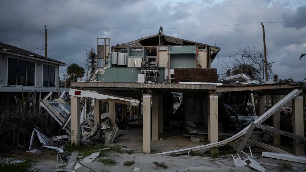 A destroyed house with cloudy skies in the background