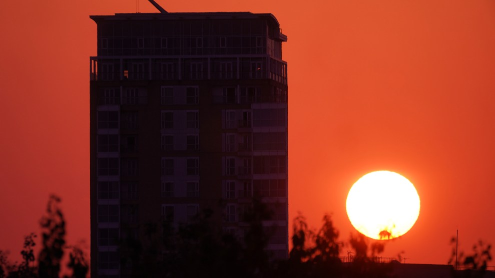 An orange sky and an apartment building. The sun is rising.