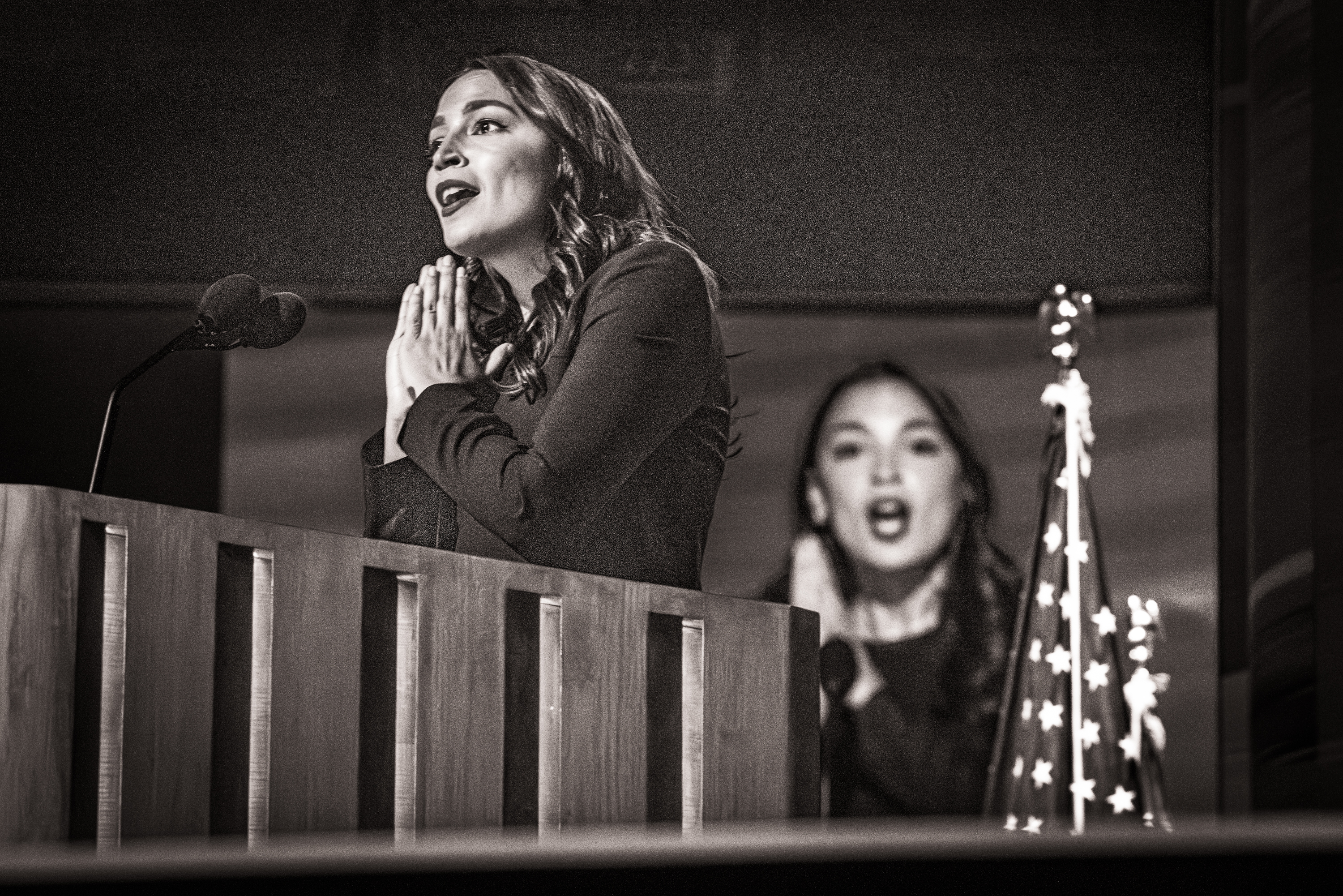 Representative Alexandria Ocasio-Cortez speaking behind a podium