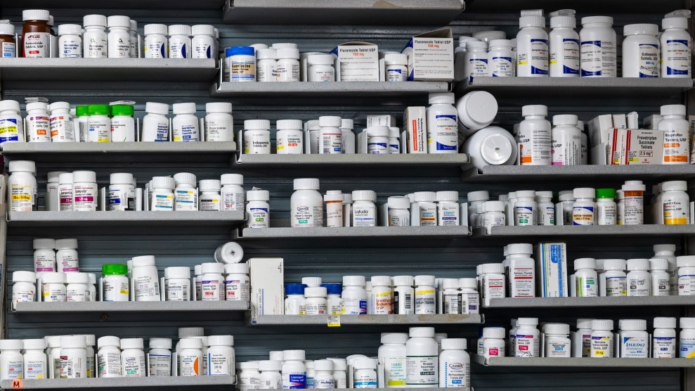 Medication, in large bottles, stacked on shelves at a pharmacy