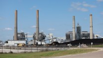 Smokestacks photographed against a blue sky with a smattering of clouds.