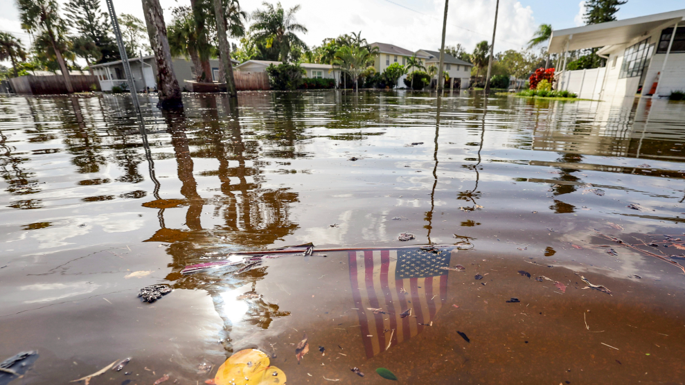 A photo of a neighborhood in St. Petersburg, Florida flooded with stormwater from Hurricane Helene. An American flag is submerged in water.