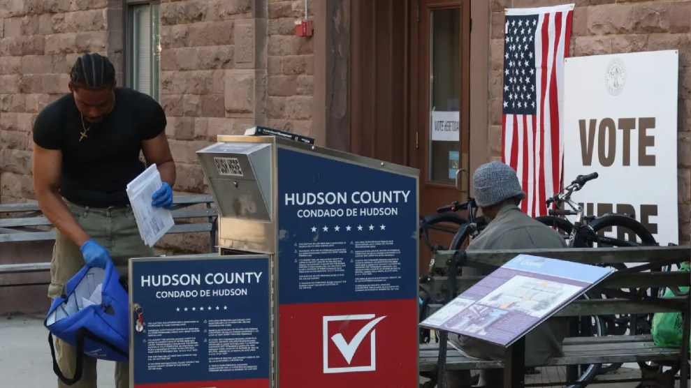 A poll worker worker collects mail in ballots