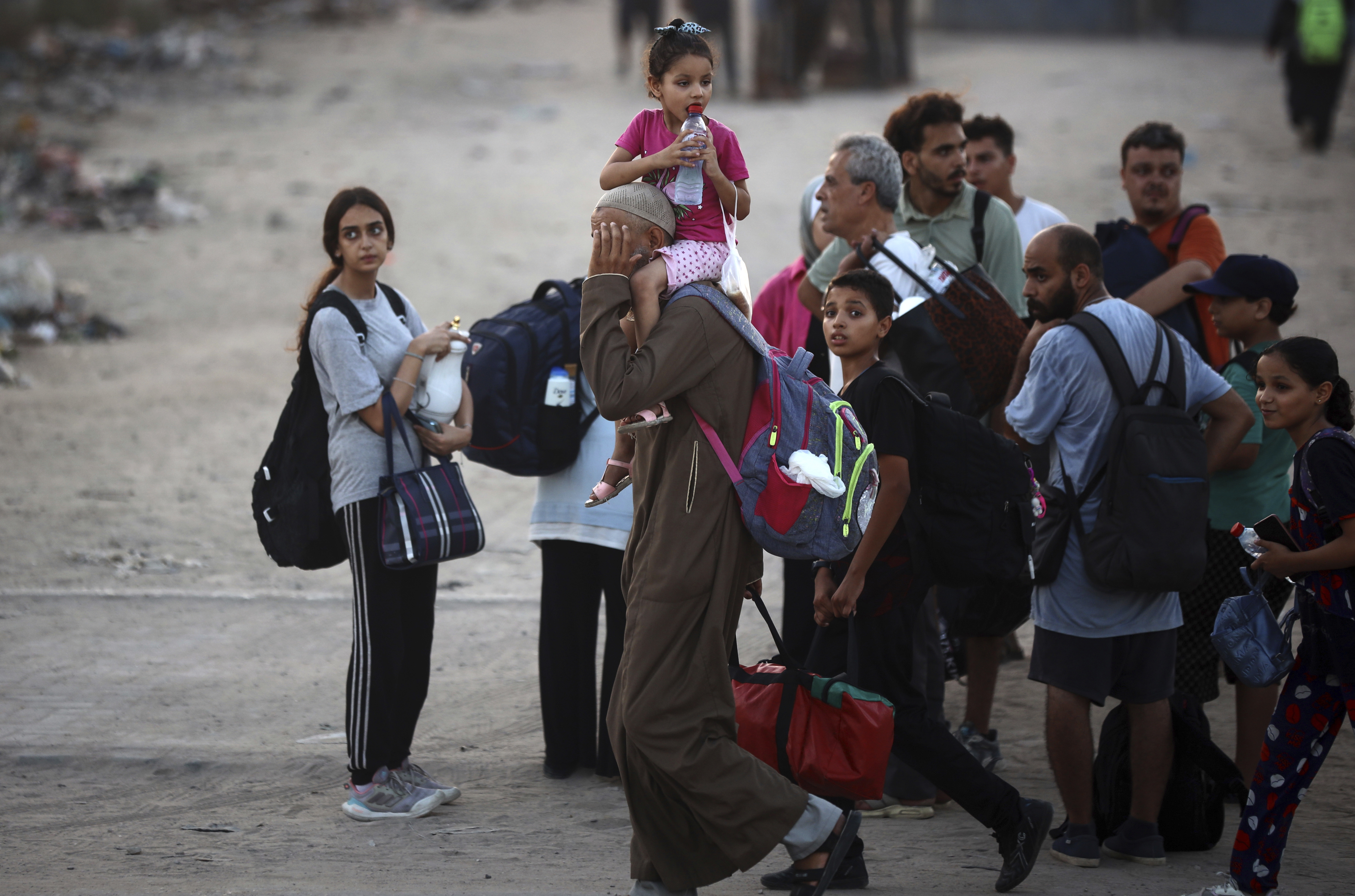 Families gather, carrying backpacks and tote bags.