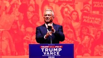 Robert Kennedy Jr. speaking in front of a red and orange tinted background