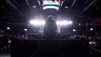 Donald Trump from behind, walking up stairs onto a stage