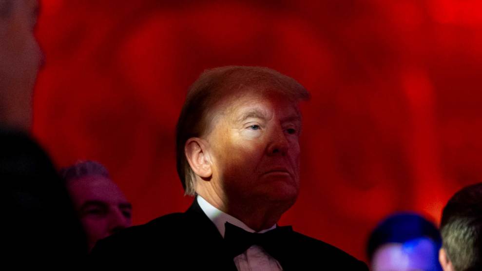 President Donald Trump standing in front of red backdrop at his Mar-a-Lago estate.