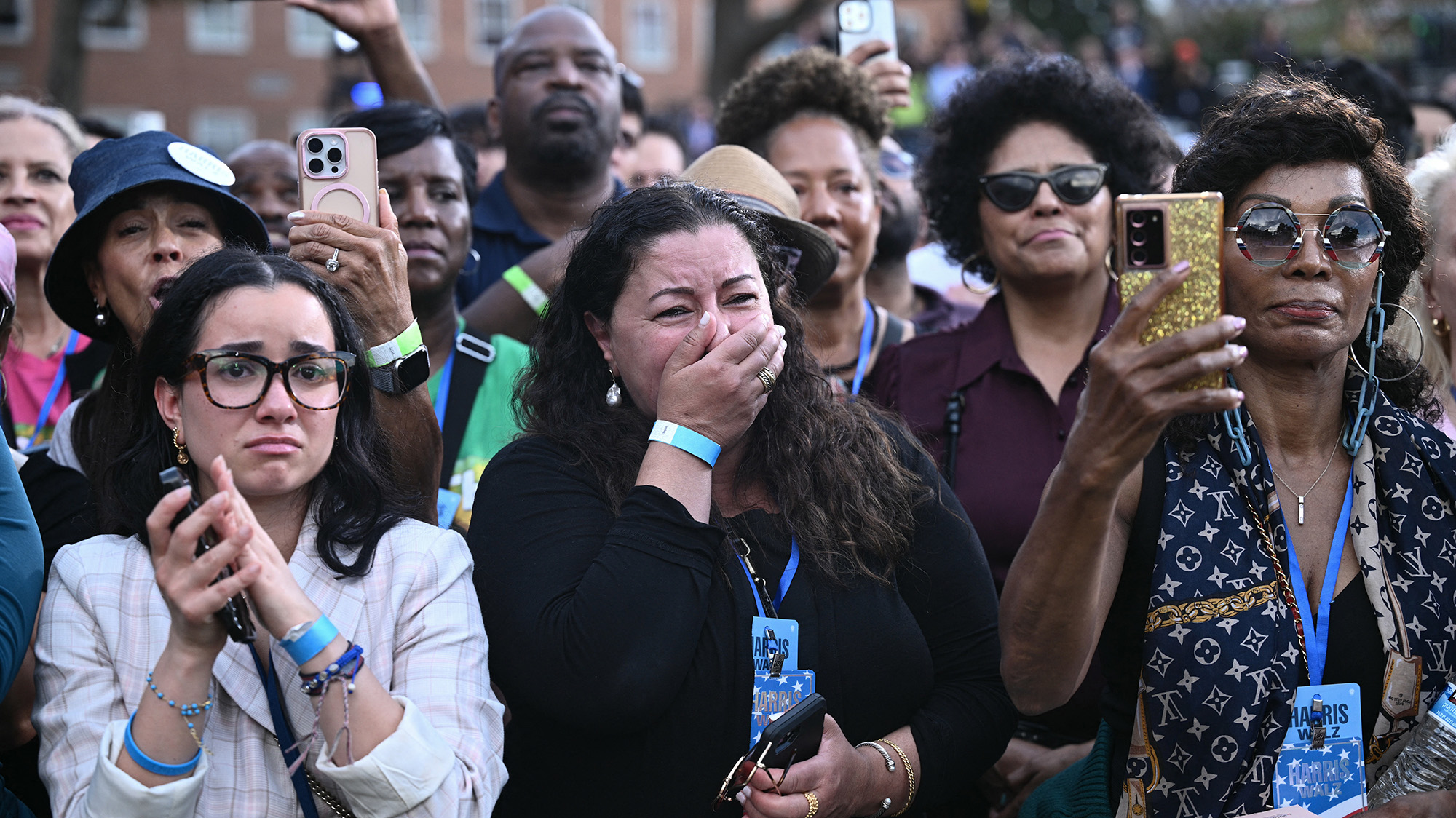 Group of women with one woman crying, holding her hand over her mouth.