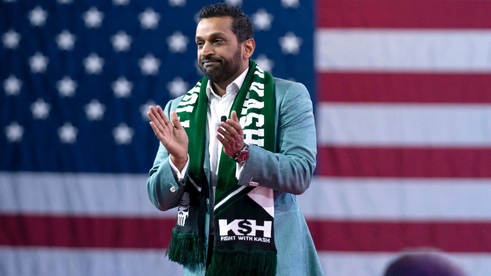 Kash Patel, in front of an American flag backdrop, gesturing with his hands