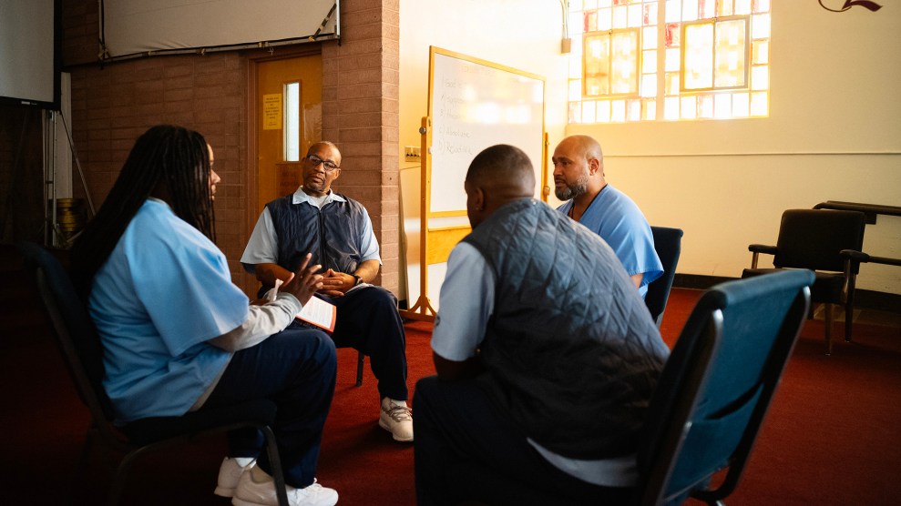 Group of four men sitting in a circle talking.