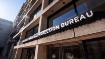 A brown building with a lot of windows with signage on it that says "Consumer Financial Protection Bureau."