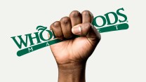 The fist of a Black person, signifying union power, enclosed around the Whole Foods Market logo.