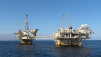 Two large yellow structures standing in the ocean.