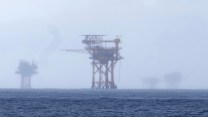 A foggy ocean with a structure in the distance.