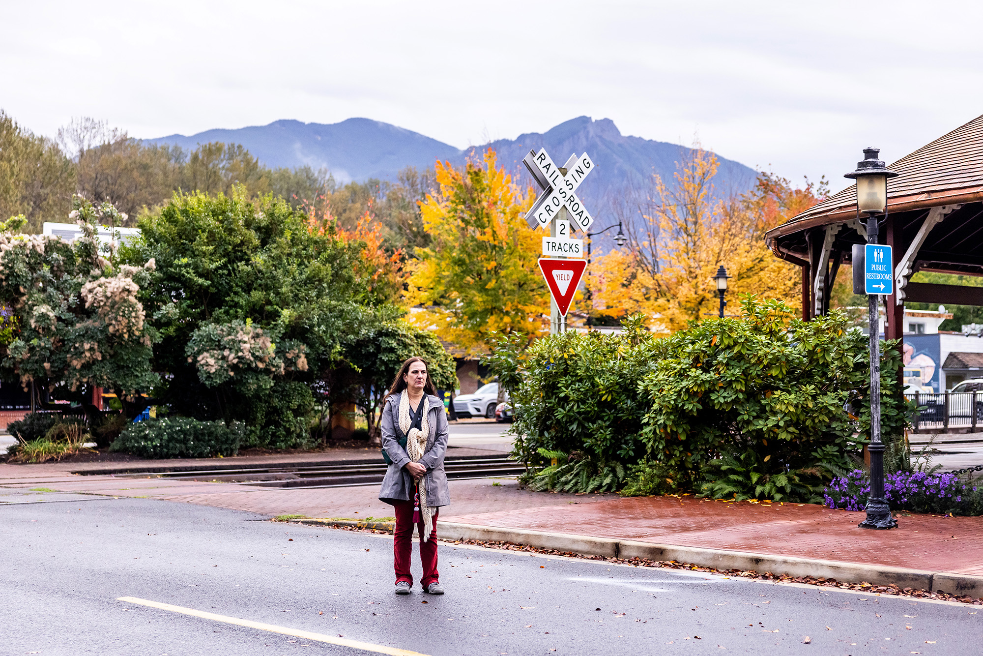 Woman standing outside, read train tracks.