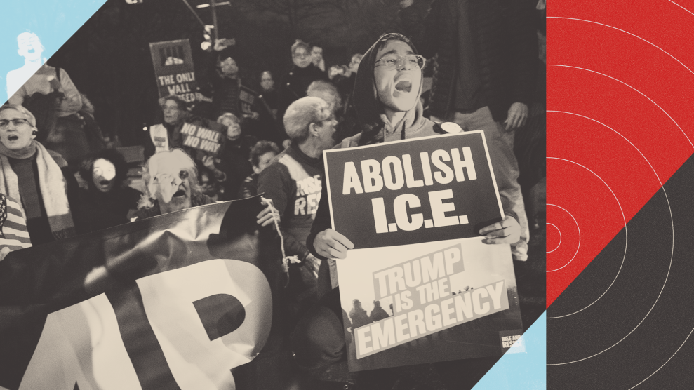 A beam of light illuminates the face of a couple of people in a crowd of protestors, who are gathered after dusk in New York outside Trump International Hotel. Many of the people are carrying signs, one of which reads "ABOLISH I.C.E. TRUMP IS THE EMERGENCY." The image is overlaid with graphic design elements, including red and black concentric circles resembling a target.