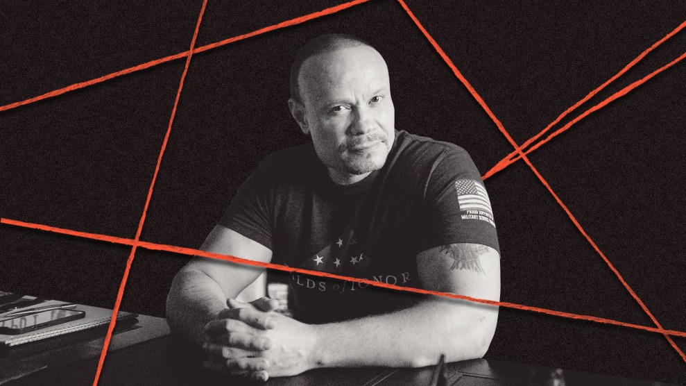 Photo illustration of Dan Bongino, a buff man with a shaved head, sitting at a desk, looking at the camera; he is surrounded by red conspiracy theory string.