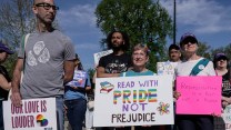 Protesters stand outside the Supreme Court building holding signs that read READ WITH PRIDE NOT PREJUDICE and REPRESENTATION IS A RIGHT NOT A PRIVILEGE.