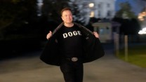 elon musk standing in front of the white house flashing a "DOGE" shirt