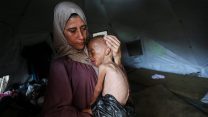 a woman holding an emaciated child