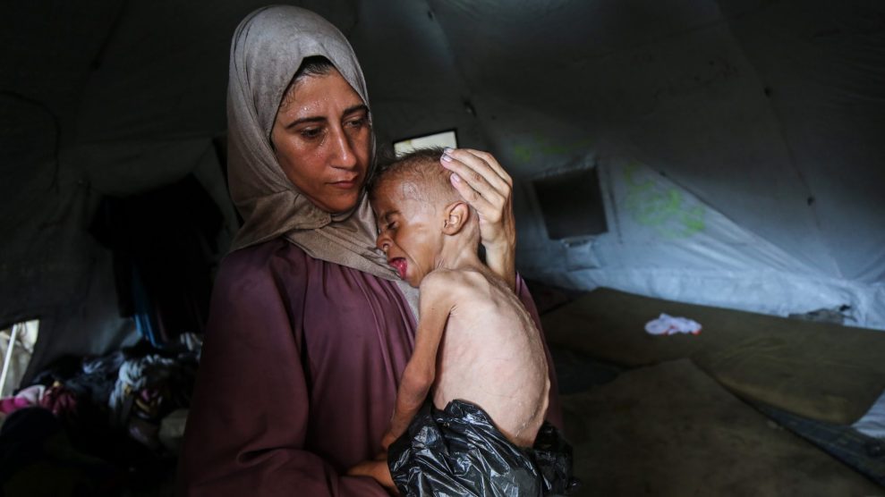 a woman holding an emaciated child