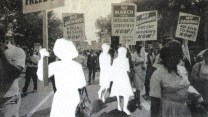 Photo illustration of an archival photo from the Civil Rights Movement where African American men and women march with signs demanding equal rights; three of the women have been cut out and removed from the image, leaving behind a white space.