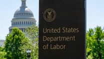 A sign in marble that says US Department of Labor on it with the Capitol building in the background.