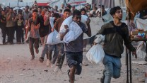 a line of people, who look haggard, getting food in Gaza