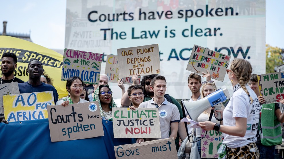 Protesters holding signs that say "The courts have spoken. The Law is clear. Climate justice now."