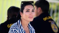 Laura Loomer wearing a blue-and-white striped shirt looking into the camera.