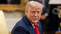 Donald Trump wearing a blue suit and a red tie with his mouth slightly ajar.