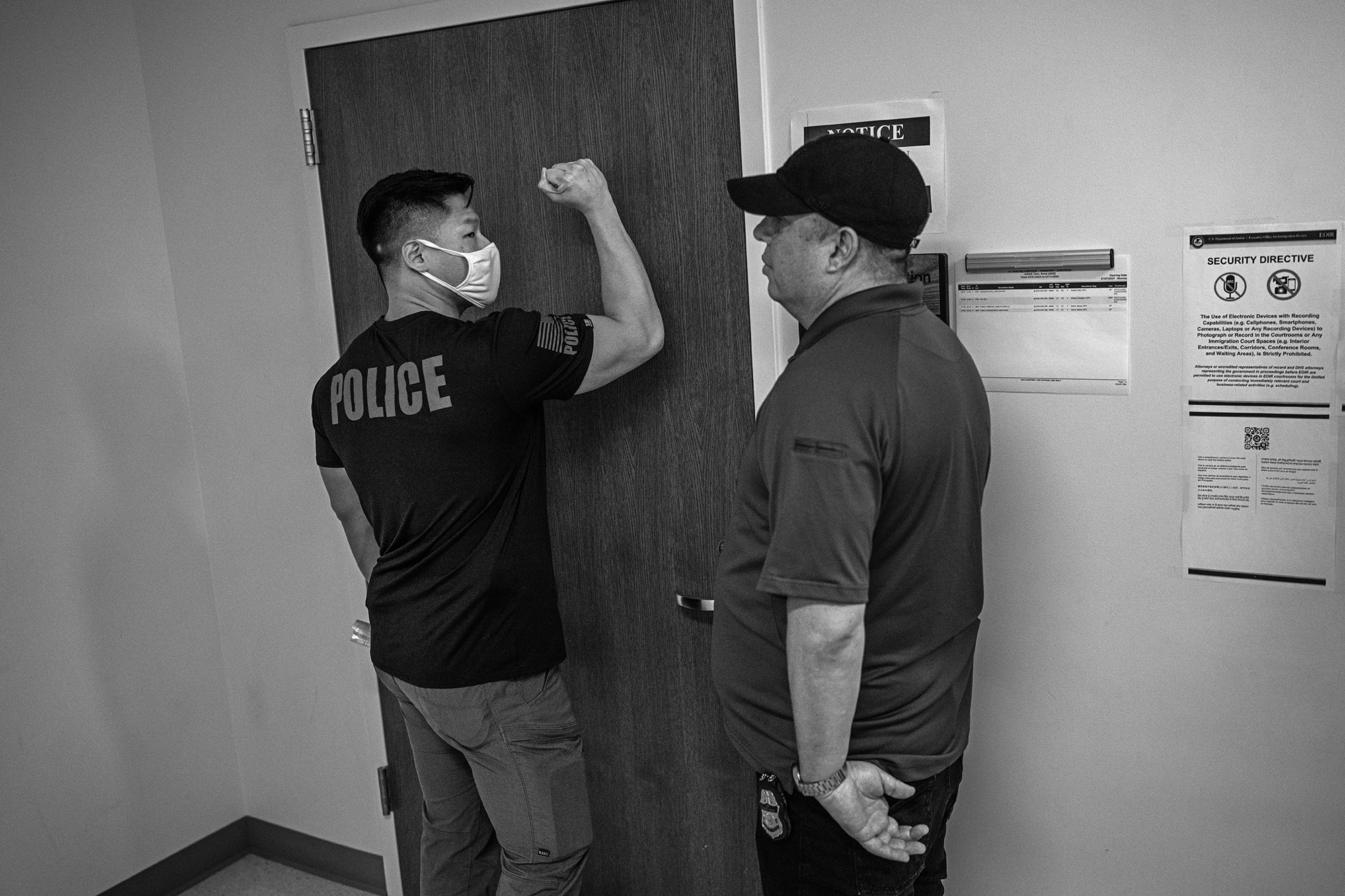 A Federal agent bangs on a closed door.