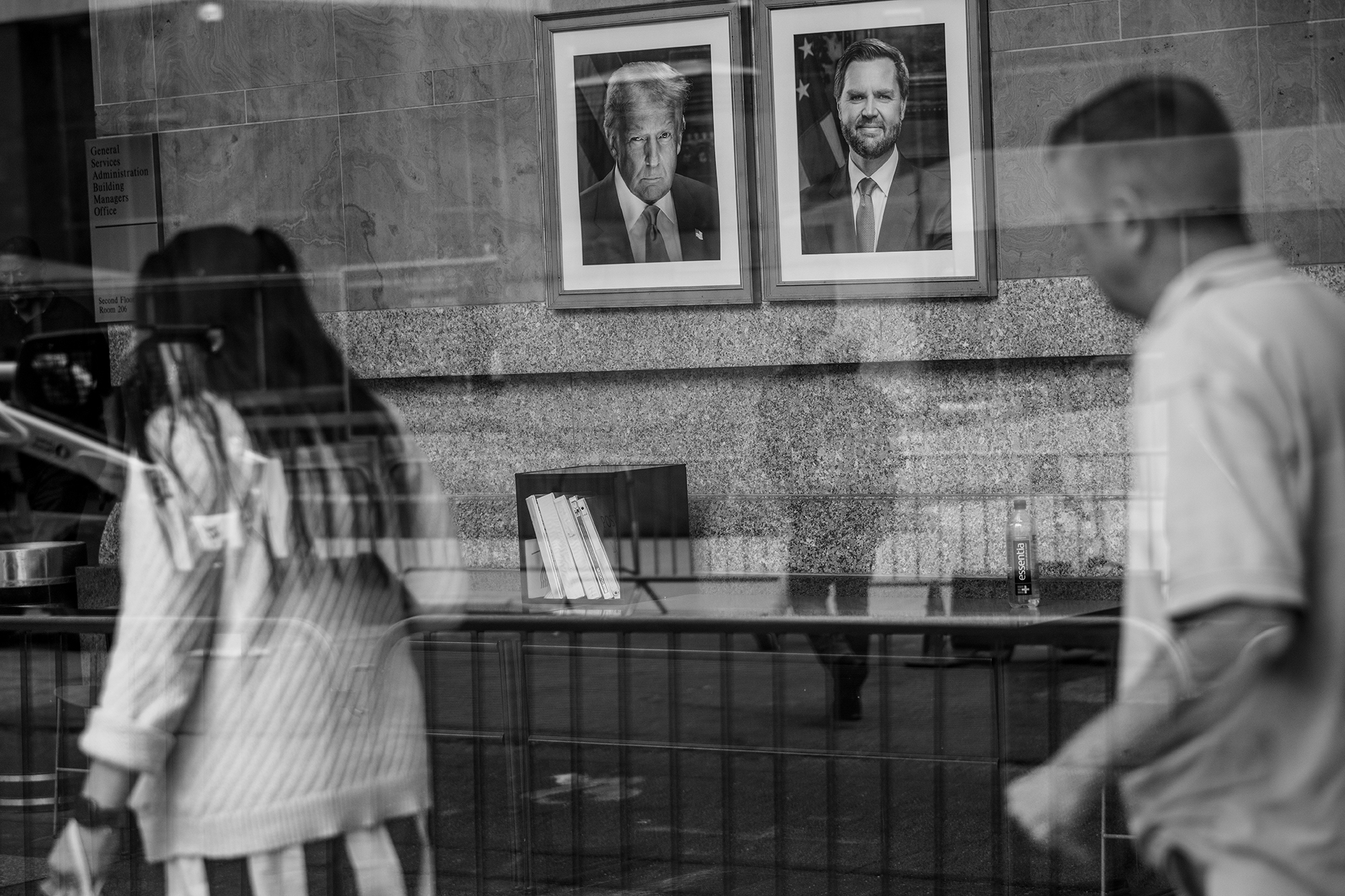 Portraits of Donald Trump and JD Vance seen through a window.
