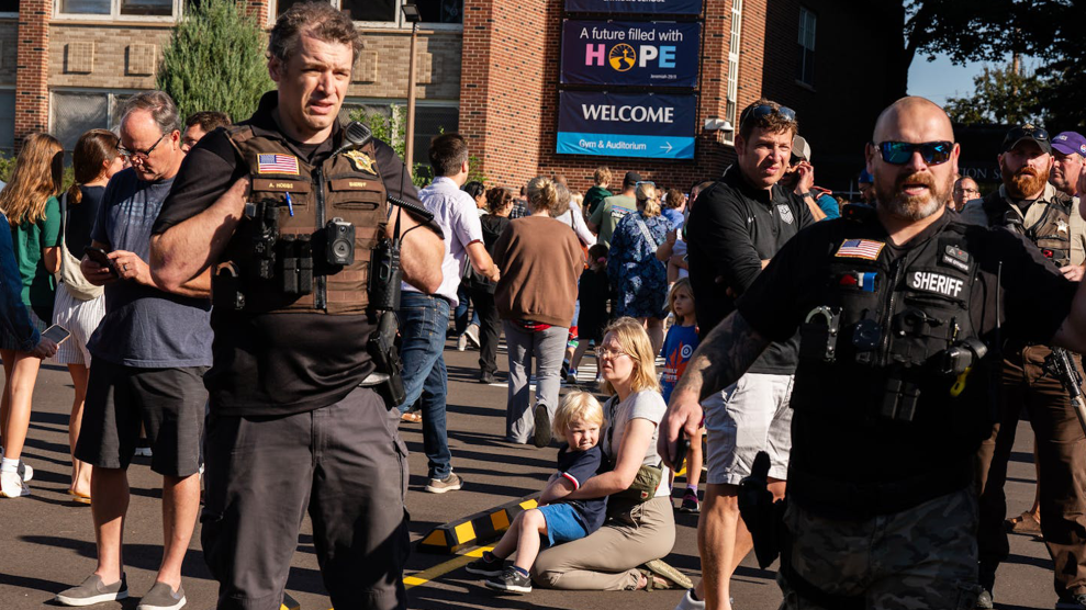 Law enforcement shown in front of the crime scene of the Catholic church in Minneapolis where a mass shooting occurred on August 27, 2025.