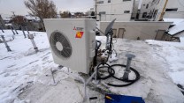 A metal box contraption on a snowy roof.