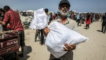 A man holds a sack of food in his hands at an aid site in Rafah.