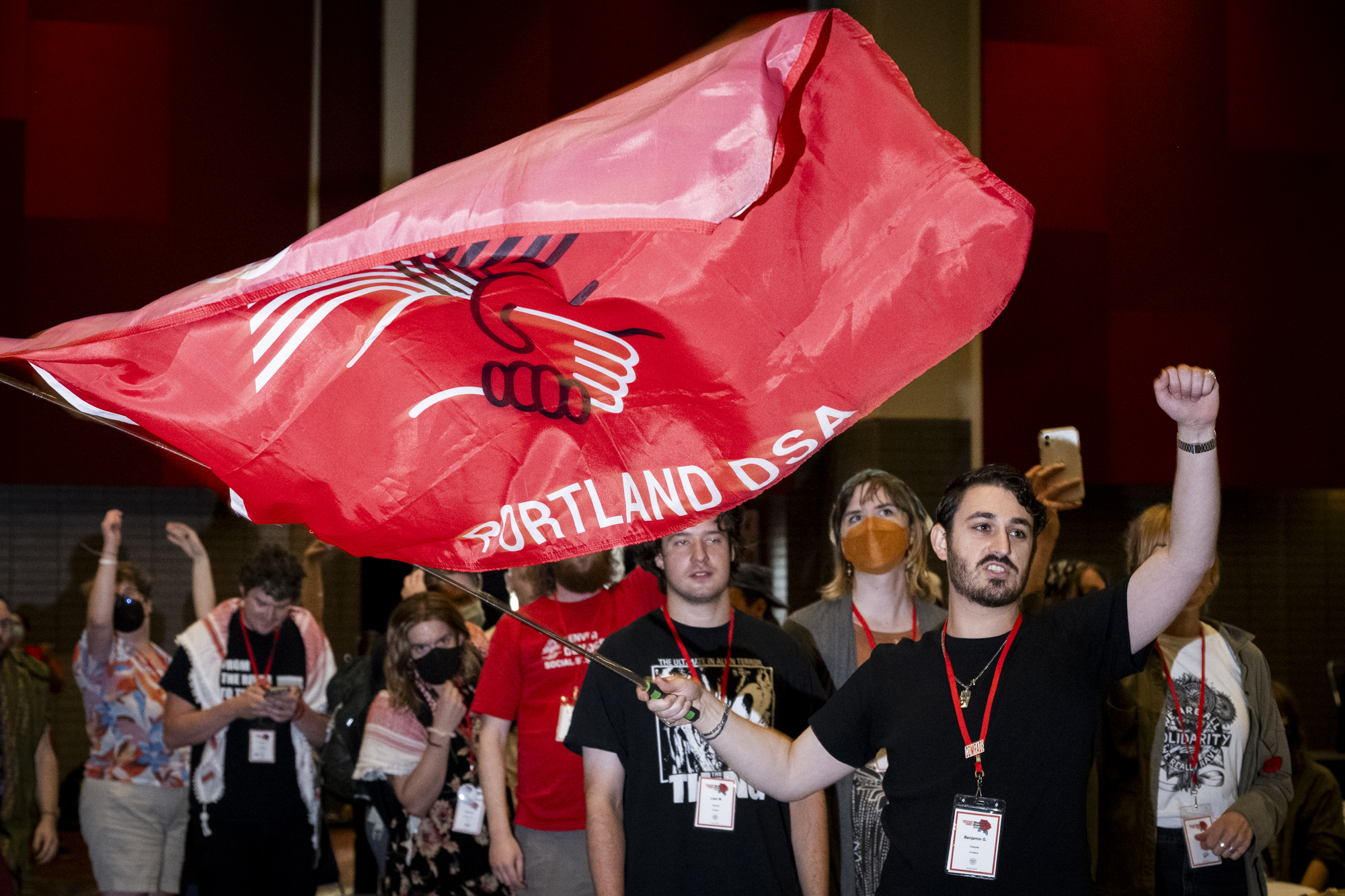 Group of people waving a large red DSA flag.