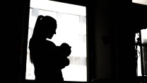 Black and white photo of woman holding baby