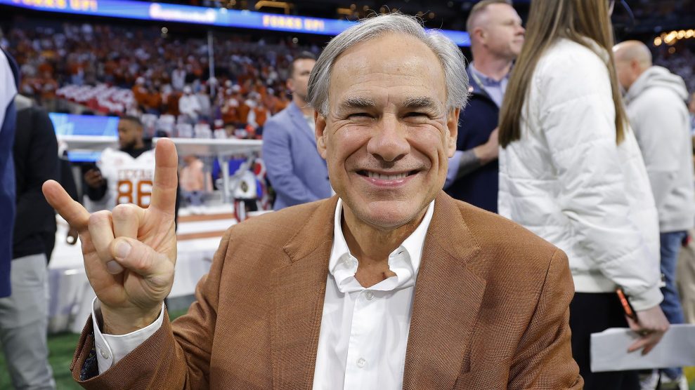 Governor Greg Abbott throws up a Texas longhorn finger gesture during a collegiate football game.
