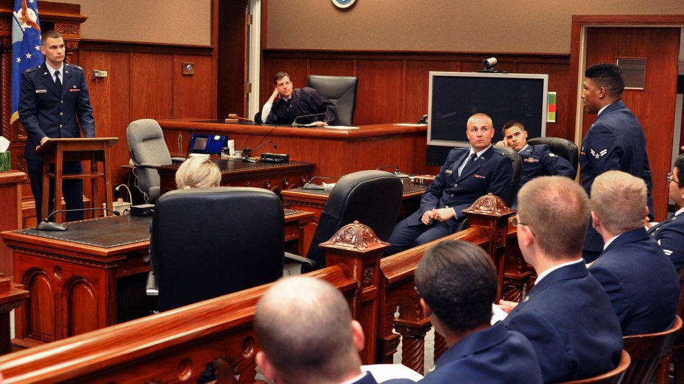 Airmen in uniform inside a courtroom.